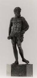 A bronze sculpture of Hercules.  His head is turned to his left.  He has a lion's pelt draped o…