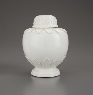 White porcelain tea caddy with raised decoration at the top and foot, and rounded top.