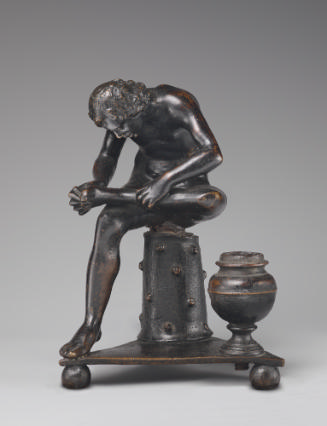Bronze sculpture of a spinario, he is seated and huddled over with his left leg propped up on h…