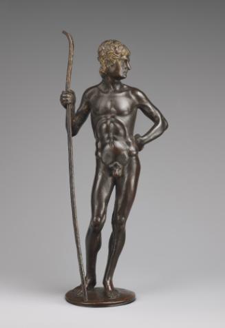 A bronze sculpture of Paris.  His head is facing to his left with his left hand resting on his …