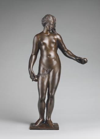 Bronze sculpture of Eve.  She is standing upright and is fully nude, her left arm is stretched …