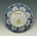 Small blue and white porcelain saucer with floral motifs, view from bottom.