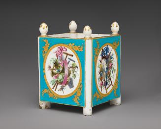 Porcelain cubical dish in blue, white, and gold with cupids and trophies