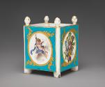 Alternate view of porcelain cubical dish in blue, white, and gold with cupids and trophies