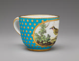 Alternate view of porcelain cup in blue and gold with image of bird