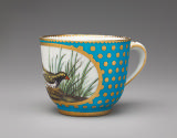 Alternate view of porcelain cup in blue and gold with image of bird
