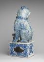 Back view of blue and white porcelain dog sitting on intricately designed base