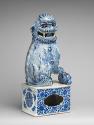 Alternate view of blue and white porcelain dog sitting on intricately designed base