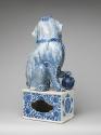 Back view of blue and white porcelain dog sitting on intricately designed base