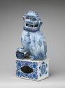 Alternate view of blue and white porcelain dog sitting on intricately designed base