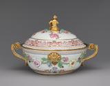 Back view of white porcelain lidded tureen with gilded handles decorated with garlands of flowe…