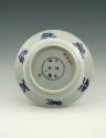 White hard-paste porcelain plate with underglaze blue decoration showing figures in a landscape…