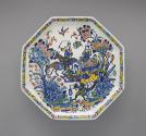 Top view of a footed platter with ornate floral and figurative decoration in color