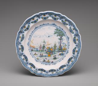 Circular plate with a landscape and decorative border in color