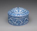 Alternate view of circular, covered powder box with blue scrollwork decoration