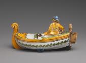 Back view of spice box in the shape of a boat and fisherman painted in yellow and green