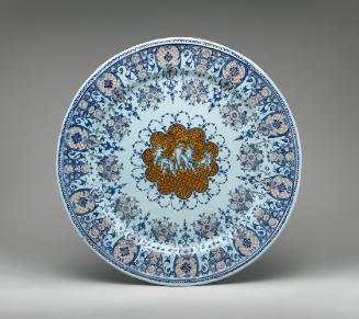 Large circular plate with putti in the middle surrounded by ornate decoration in red and blue