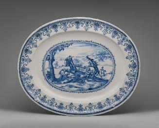 Large oval platter with a hunting scene in the center and decorative border in blue and white