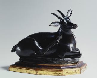 Bronze sculpture of a reclining antelope.