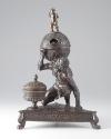 Bronze sculpture of crouching man supporting globe with triangular base; front view