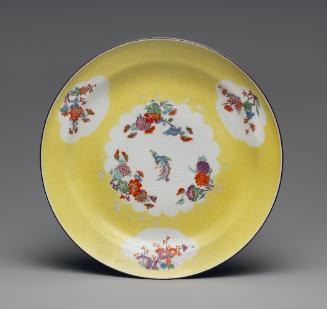 Image of plate with a light yellow ground and four cartouches with floral bouquets; the one in …