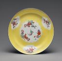 Image of plate with a light yellow ground and four cartouches with floral bouquets; the one in …