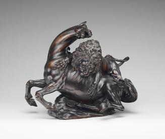 A bronze sculpture of a lion attacking a horse.  The lion is actively clawing and biting into t…