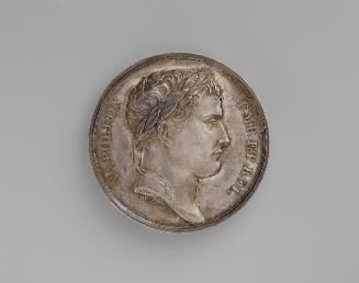 Silver medal of a man in profile to the right with short hair and a laureate