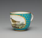 Alternate view of porcelain cup in blue and gold with image of bird