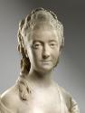 Alternate view of a marble bust of Madame His.  She has long curly hair that is elaborately pin…
