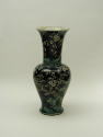 Black ground porcelain vase with rocks, branches, and white flowers