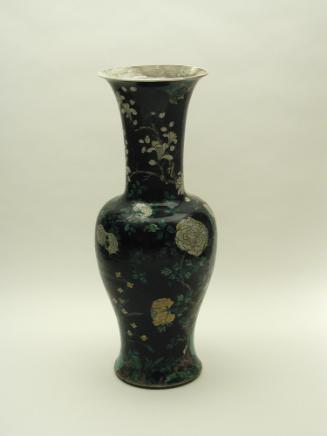 Tall porcelain vase with black ground and floral and vegetal designs