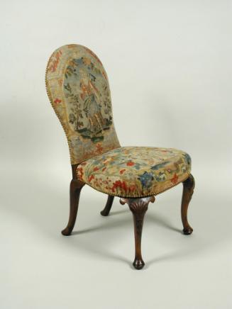 Chair with needlepoint upholstery showing woman standing outdoors, with birds and vegetal decor…