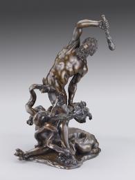 Bronze sculpture of a man raising a club above a monster