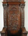 View of back of walnut armchair with high back and relief carving shpwing vegetal motifs and fi…