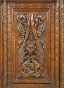 Detail of carved decoration from cabinet, showing masks