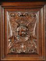 Detail of carved decoration from cabinet, showing head of cherub