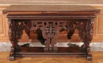 Side view of walnut table with carved openwork supports