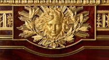 Detail of gilt bronze mask with laurel branches and radiating rays of sunlight