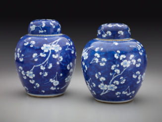 Pair of blue porcelain covered jars decorated with white floral decorations.