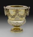 Gold and silver wine cooler with plant designs and rams' heads