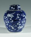 Single blue porcelain covered jar decorated with white floral decorations.