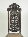 View of walnut chair back with openwork carving