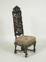 Walnut chair with openwork back and embroidered seat showing flowers, fruit, and insects