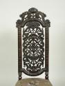 View of walnut chair back with openwork carving