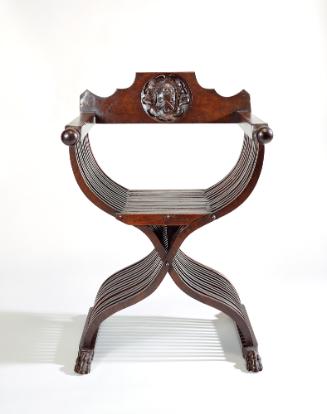 Walnut folding armchair with central crest