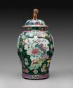 Large porcelain covered jar with famille rose decoration and black ground surmounted by figure …