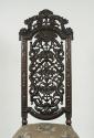 View of walnut chair back with openwork carving