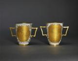 Image of a pair of two-handled beakers with heavily gilded chinoiserie cartouches 