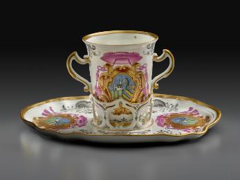 White porcelain two-handled armorial trembleuse on a saucer with gilded rim and handles